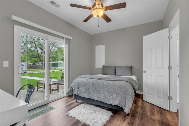 bedroom with visible vents, wood finished floors, access to outside, and ceiling fan