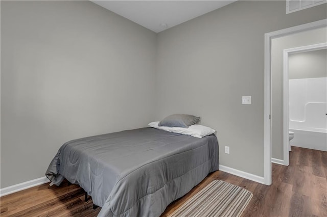 bedroom with wood finished floors, visible vents, and baseboards
