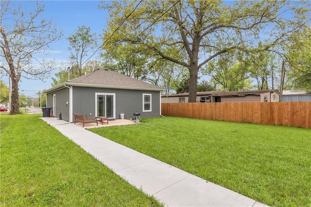 back of property with a lawn, a patio area, and fence