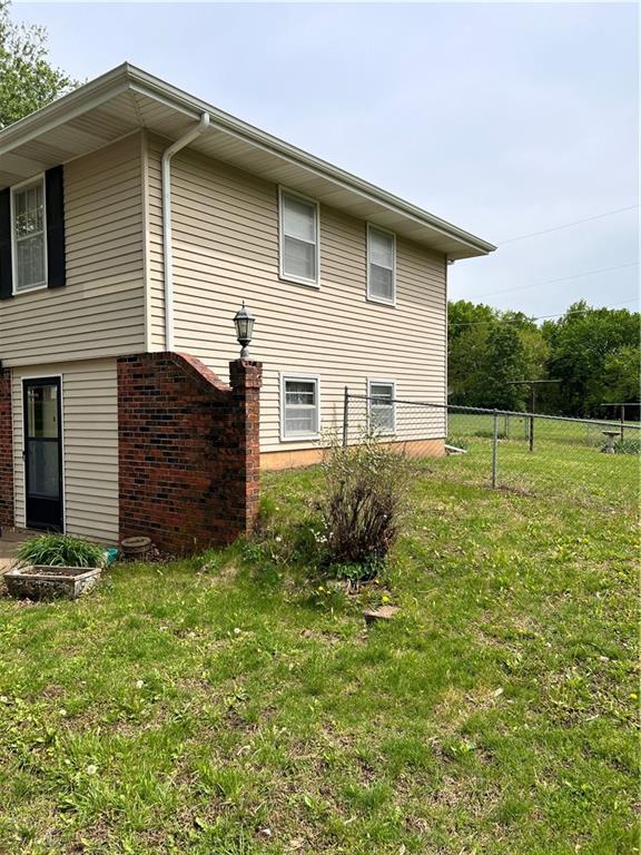 view of home's exterior featuring fence and a yard