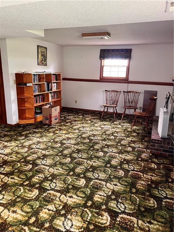 spare room featuring visible vents, carpet, and a textured ceiling