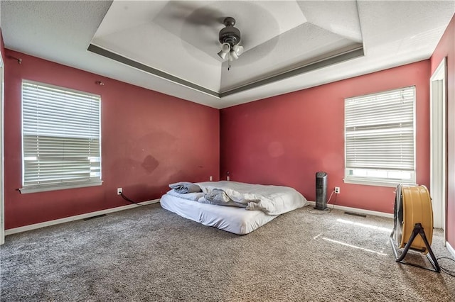 1904 NW Harbor Pl, Blue Springs, MO 64015 - carpeted bedroom featuring a tray ceiling, baseboards, and a ceiling fan