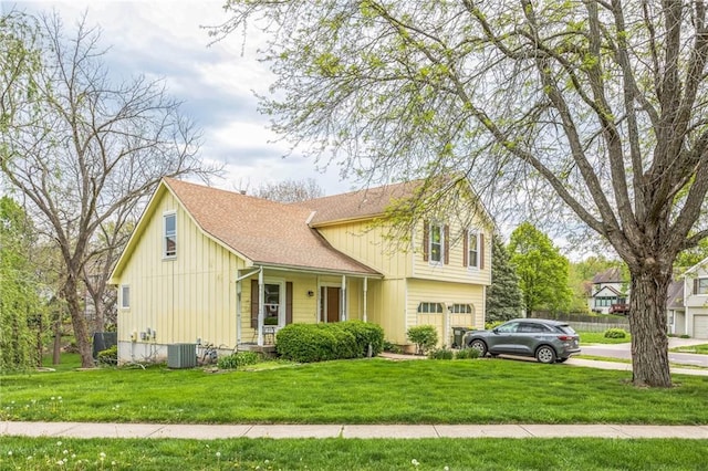 traditional-style home featuring central air condition unit, driveway, a front yard, a garage, and board and batten siding