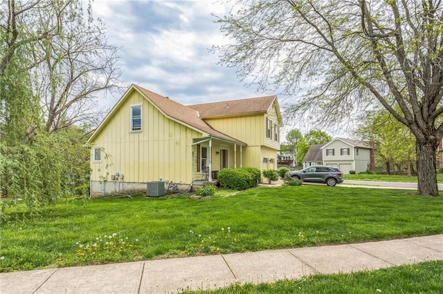view of home's exterior featuring board and batten siding, cooling unit, a lawn, and a shingled roof