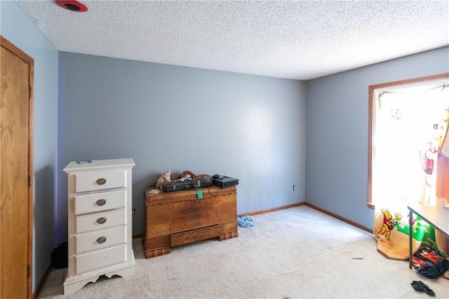 carpeted bedroom with a textured ceiling and baseboards