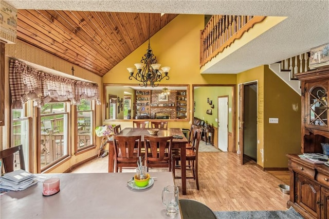 dining room featuring wood finished floors, a chandelier, high vaulted ceiling, wood ceiling, and baseboards