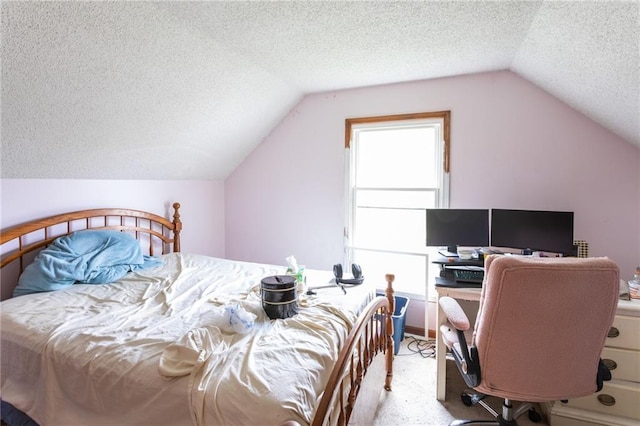 bedroom with a textured ceiling, vaulted ceiling, carpet flooring, and a desk