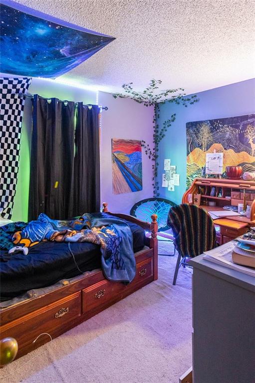 bedroom featuring a textured ceiling and carpet floors