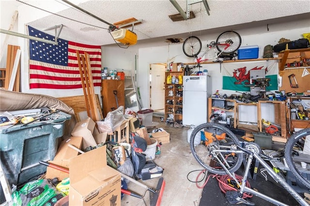garage with freestanding refrigerator, a garage door opener, and a workshop area
