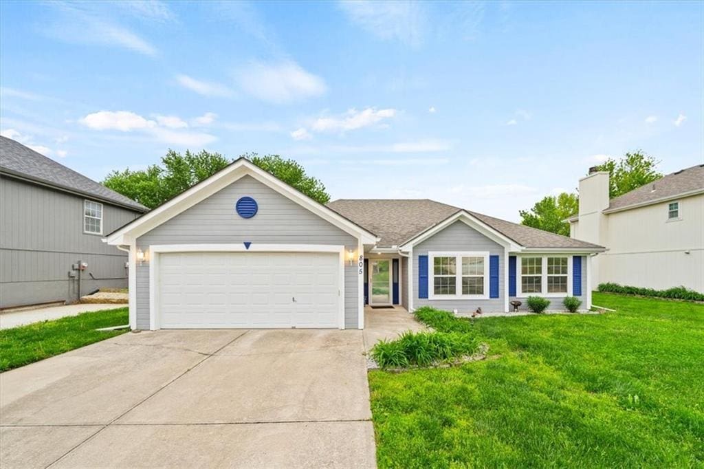 ranch-style house featuring an attached garage, a front lawn, and concrete driveway