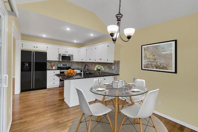 dining room with light wood-style floors, baseboards, recessed lighting, and a notable chandelier