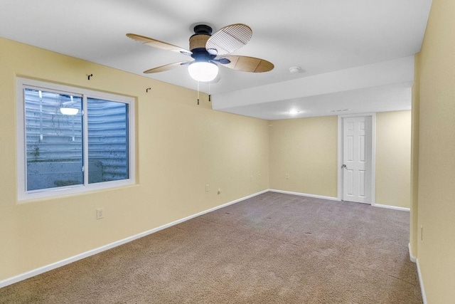 empty room with ceiling fan, baseboards, and carpet