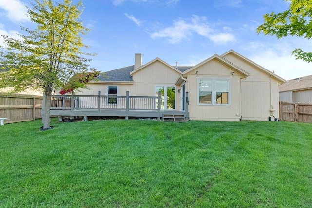 back of house featuring a lawn, a fenced backyard, a wooden deck, and a chimney