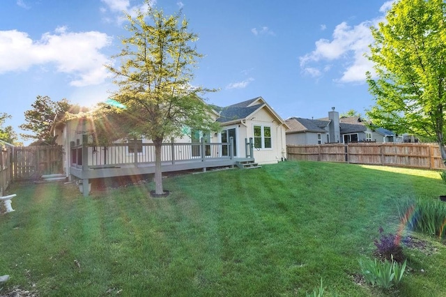 view of yard with a wooden deck and a fenced backyard
