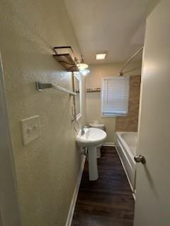 bathroom with wood finished floors and baseboards