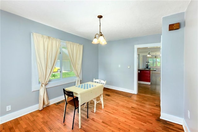 314 N Lake St, Pleasant Hill, MO 64080 - dining space featuring baseboards, visible vents, light wood-type flooring, and a notable chandelier