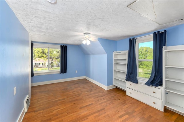 314 N Lake St, Pleasant Hill, MO 64080 - additional living space featuring ceiling fan, baseboards, wood finished floors, vaulted ceiling, and visible vents