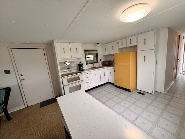 15823 Colorado Pl, Princeton, MO 64673 - kitchen with freestanding refrigerator, range with two ovens, white cabinetry, light countertops, and light flooring