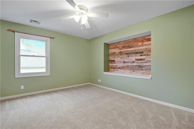 unfurnished room featuring carpet flooring, ceiling fan, baseboards, and a textured ceiling