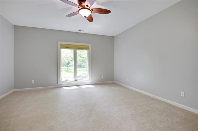 empty room featuring light carpet, baseboards, and a ceiling fan