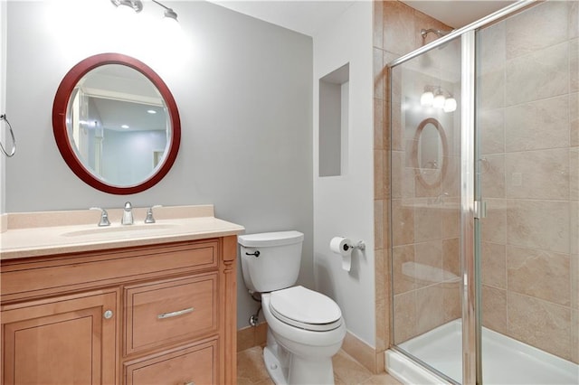bathroom with a shower stall, toilet, and vanity