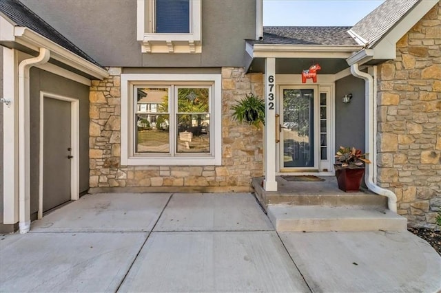 6732 Clairborne Rd, Shawnee, KS 66217 - doorway to property with stone siding, stucco siding, and roof with shingles