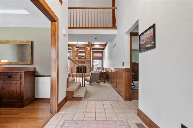 6732 Clairborne Rd, Shawnee, KS 66217 - foyer entrance with light carpet, a ceiling fan, light wood finished floors, a fireplace, and a wainscoted wall