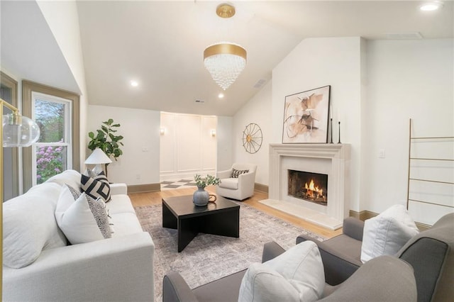 9440 Manor Rd, Leawood, KS 66206 - living room featuring lofted ceiling, light wood-style floors, a lit fireplace, and baseboards