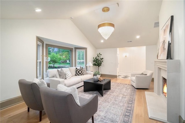 9440 Manor Rd, Leawood, KS 66206 - living area with lofted ceiling, light wood finished floors, a lit fireplace, and baseboards