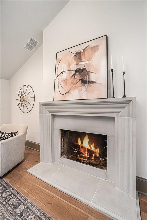 9440 Manor Rd, Leawood, KS 66206 - detailed view of wood finished floors, a warm lit fireplace, and baseboards