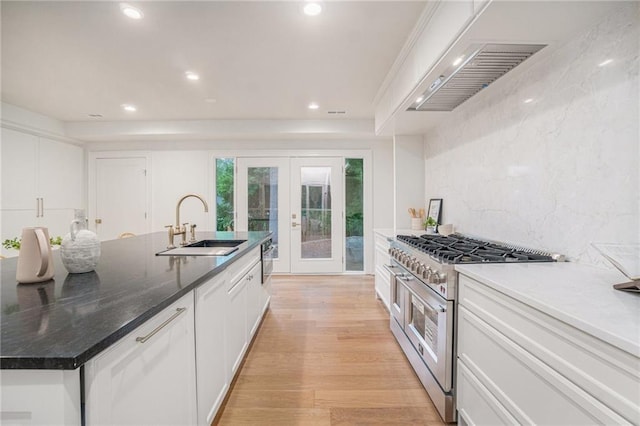9440 Manor Rd, Leawood, KS 66206 - kitchen with high end range, french doors, a sink, white cabinets, and recessed lighting