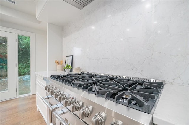 9440 Manor Rd, Leawood, KS 66206 - kitchen view of stainless steel range, light countertops, light wood-type flooring, and white cabinetry