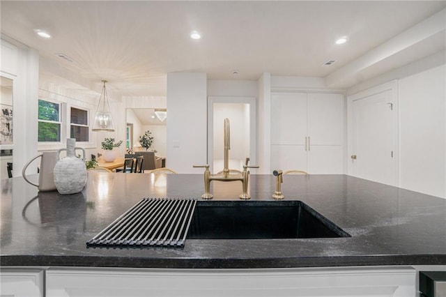 9440 Manor Rd, Leawood, KS 66206 - kitchen featuring dark stone countertops, white cabinets, recessed lighting, and pendant lighting