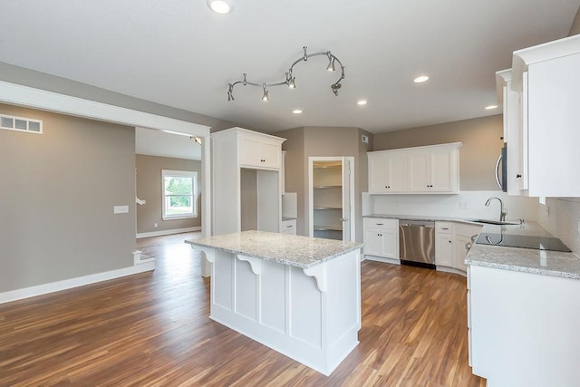 kitchen featuring light stone counters, a sink, stainless steel appliances, dark wood-type flooring, and visible vents