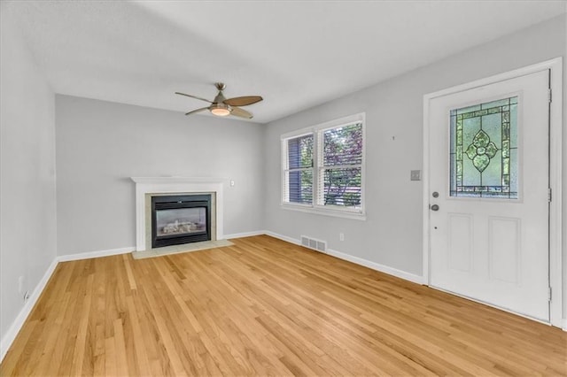 7934 Maple St, Prairie Village, KS 66208 - unfurnished living room featuring light wood finished floors, a fireplace with flush hearth, baseboards, and a ceiling fan