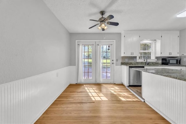 7934 Maple St, Prairie Village, KS 66208 - kitchen with dishwasher, black microwave, light wood-style floors, white cabinets, and a textured ceiling