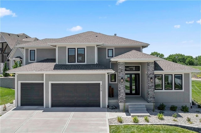 prairie-style home featuring a shingled roof, an attached garage, stucco siding, french doors, and driveway