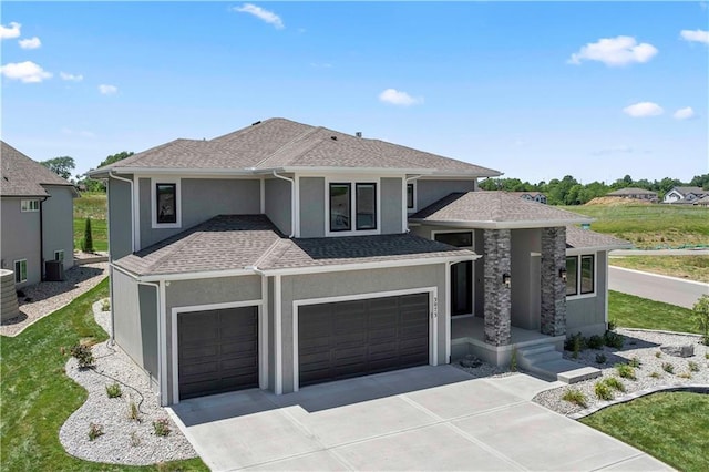 view of front of property with driveway, central AC, an attached garage, a shingled roof, and stucco siding