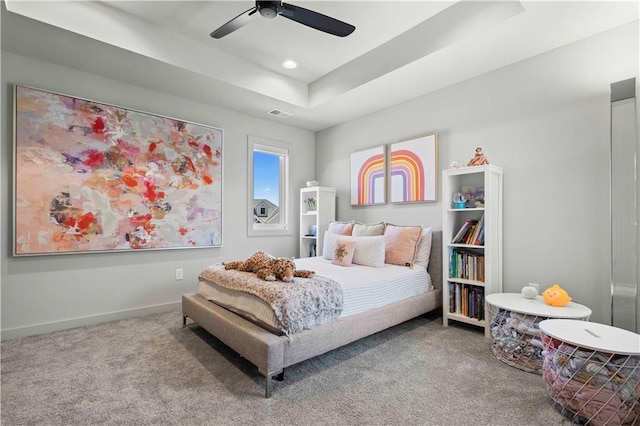 carpeted bedroom featuring visible vents, baseboards, ceiling fan, recessed lighting, and a tray ceiling