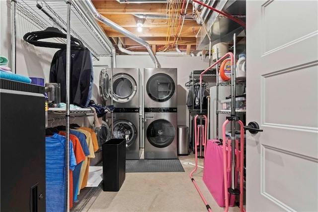 clothes washing area with stacked washing maching and dryer