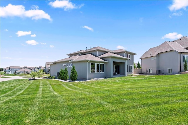 rear view of property with a yard and central air condition unit