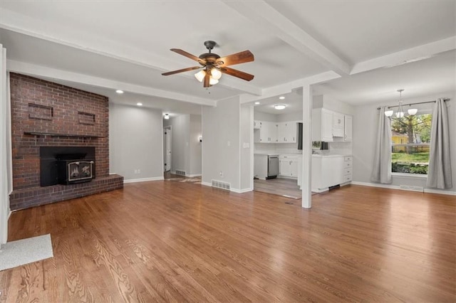 10401 Cypress Dr, Kansas City, MO 64137 - unfurnished living room with visible vents, baseboards, beamed ceiling, ceiling fan with notable chandelier, and light wood finished floors