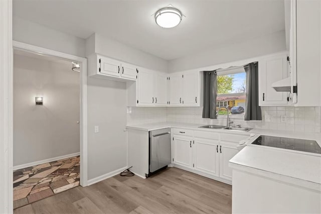 10401 Cypress Dr, Kansas City, MO 64137 - kitchen with stainless steel dishwasher, decorative backsplash, white cabinetry, a sink, and light wood-style flooring
