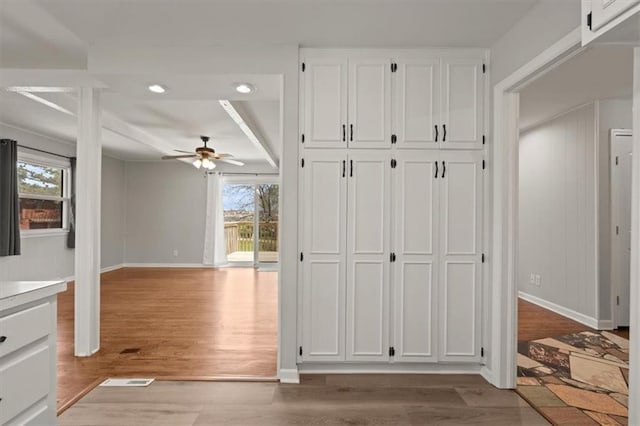 10401 Cypress Dr, Kansas City, MO 64137 - interior space featuring baseboards, ceiling fan, light wood-type flooring, and white cabinetry