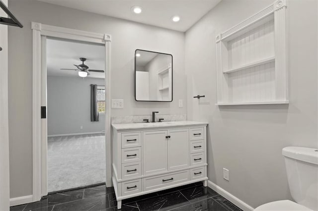 10401 Cypress Dr, Kansas City, MO 64137 - bathroom featuring ceiling fan, vanity, toilet, marble finish floor, and baseboards