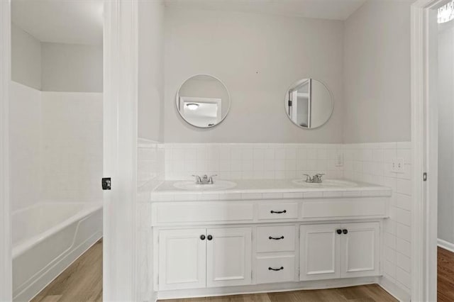 10401 Cypress Dr, Kansas City, MO 64137 - full bath featuring a sink, double vanity, and wood finished floors