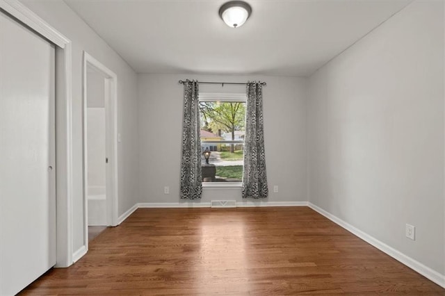 10401 Cypress Dr, Kansas City, MO 64137 - unfurnished room featuring baseboards, wood finished floors, and visible vents