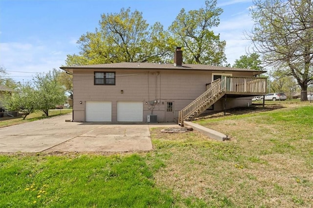 10401 Cypress Dr, Kansas City, MO 64137 - rear view of property with a garage, a deck, a chimney, stairs, and a yard
