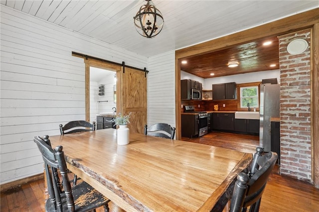505 W 6th St, Urich, MO 64788 - dining room featuring dark wood-style flooring, a barn door, wood walls, a chandelier, and wooden ceiling