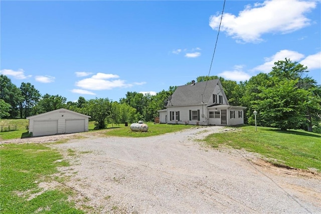 505 W 6th St, Urich, MO 64788 - view of front of property featuring a detached garage, an outbuilding, and a front lawn